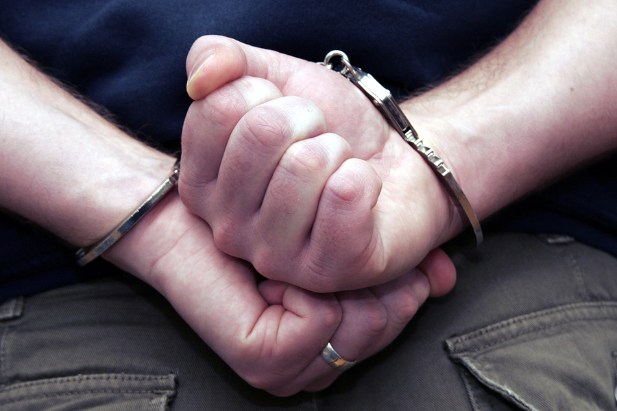 Male hands in handcuffs needing a criminal defense attorney Frisco, TX for help with Defense for Weapons Charges.