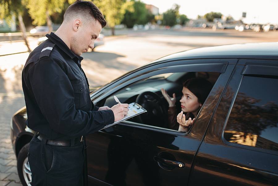 Male police officers check vehicle on the road - top crimes in texas, taking a closer look at Frisco's top crimes